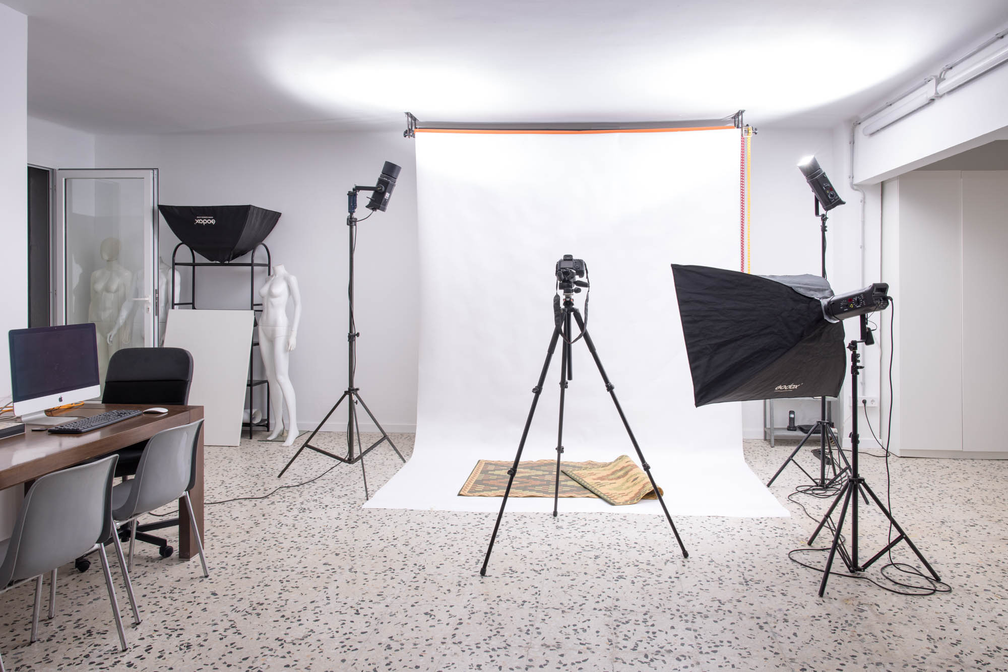 Plató con fondo continuo blanco, cámara en trípode y flashes en el estudio de alquiler de Poble Sec